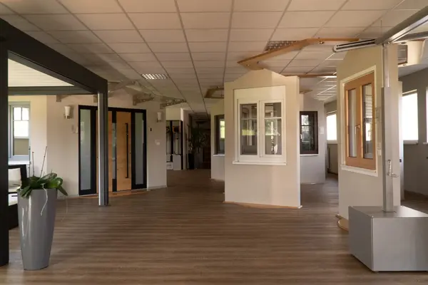 Moderne Ausstellung von Fenstern und Türen in einem hellen Showroom mit Holzoptik-Boden.